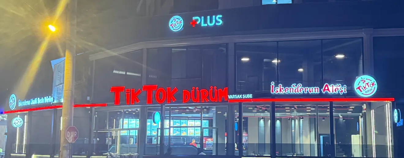 The lit TikTok Dürüm sign of the Varsak branch at night